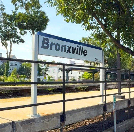 Bronxville NY Metro-North train station sign welcoming residents and visitors to the historic Village of Bronxville in Westchester County, New York.