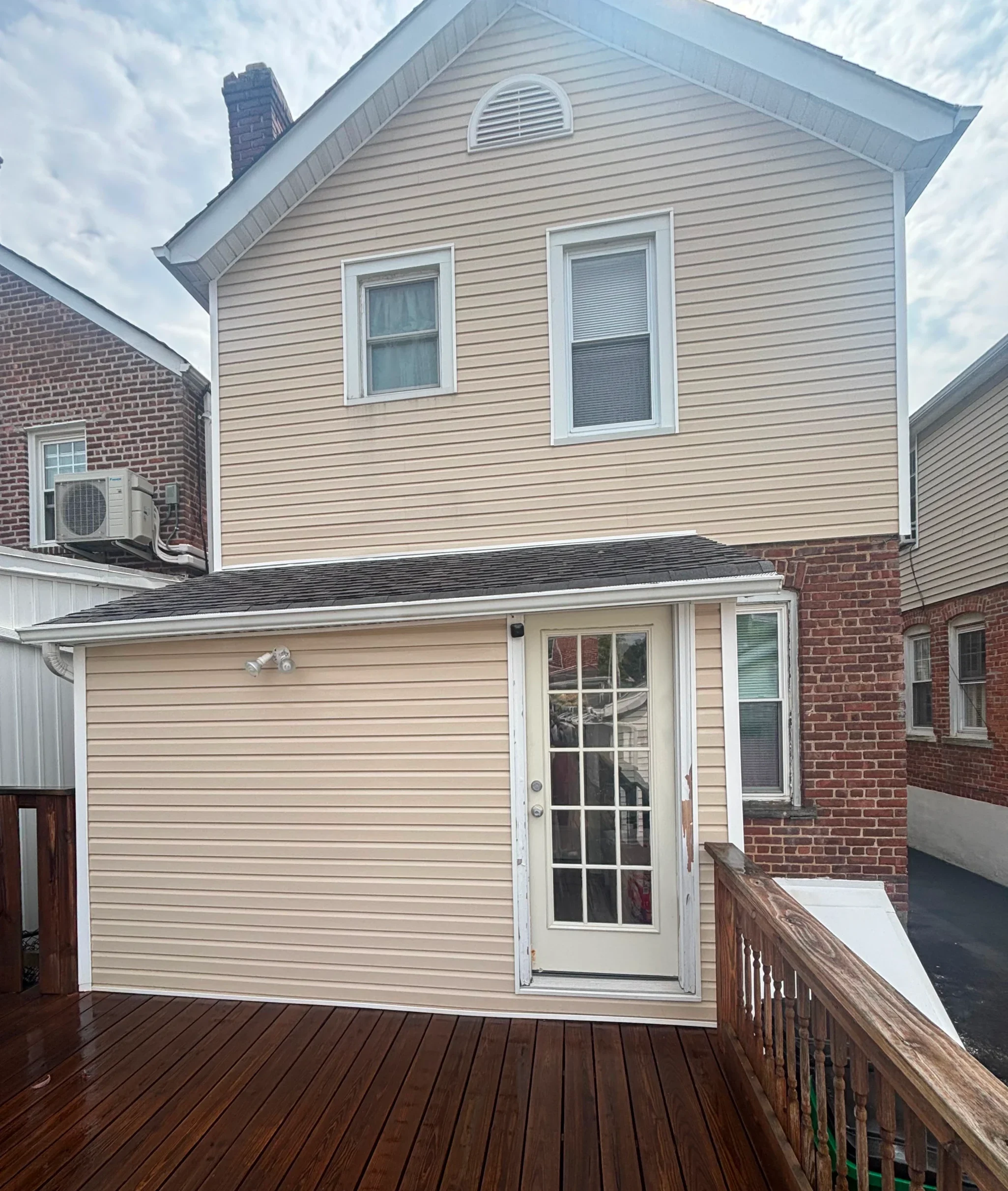 Clean vinyl siding house and restored wood deck after professional power washing in Yonkers, NY
