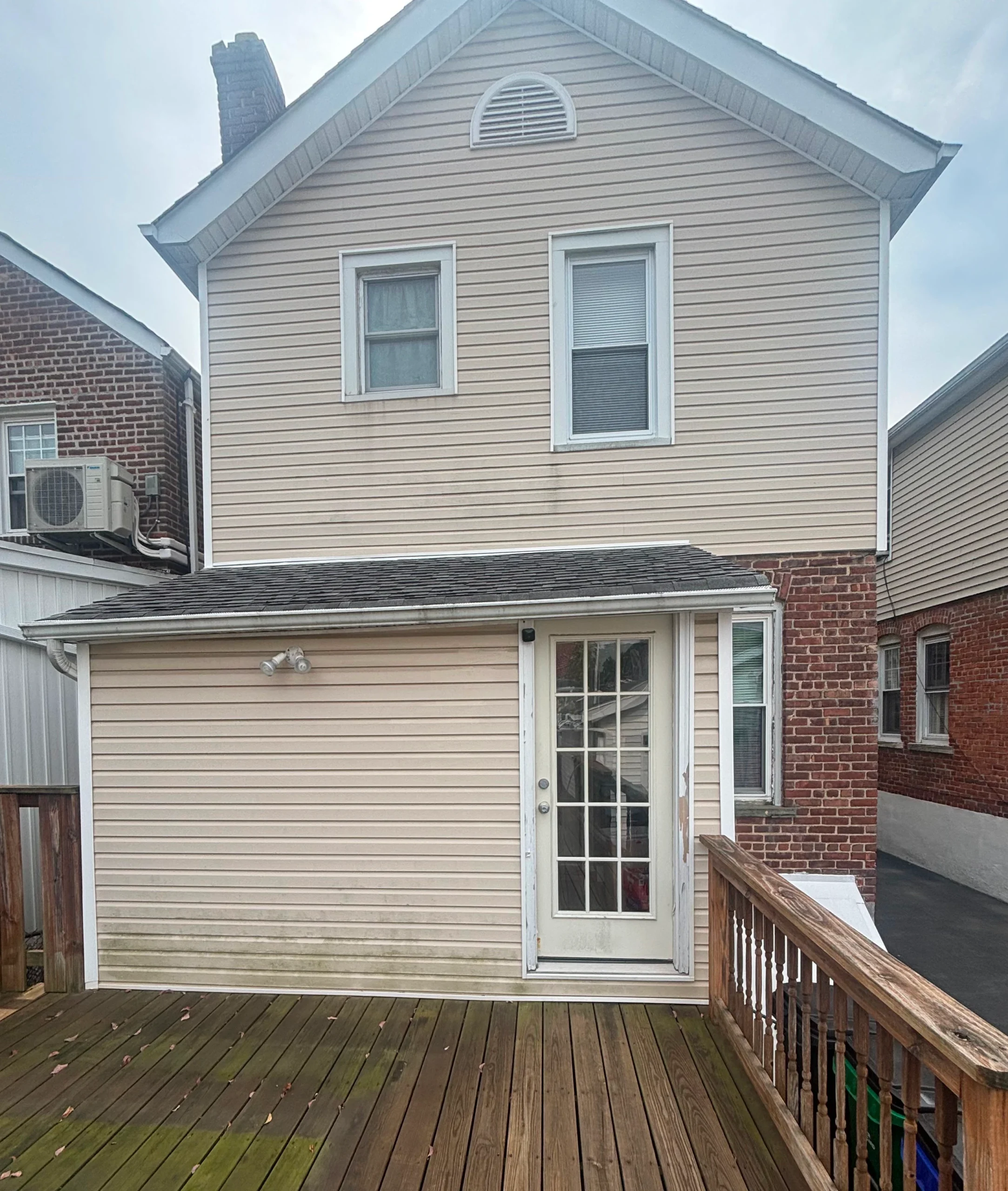 Vinyl siding house and wood deck before professional power washing in Yonkers, NY
